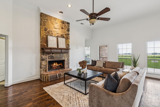 3076 W Alamosa Dr, Terrell, TX 75160 - living room with ornamental molding, wood finished floors, a stone fireplace, ceiling fan, and baseboards