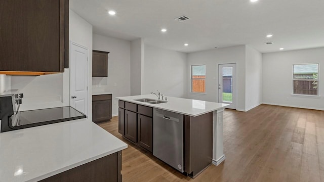 434 Drake Dr, Ferris, TX 75125 - kitchen with stainless steel dishwasher, light wood-type flooring, light countertops, open floor plan, and recessed lighting