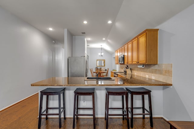 2001 Robincreek Cv, Forney, TX 75126 - kitchen with appliances with stainless steel finishes, backsplash, a peninsula, a sink, and vaulted ceiling