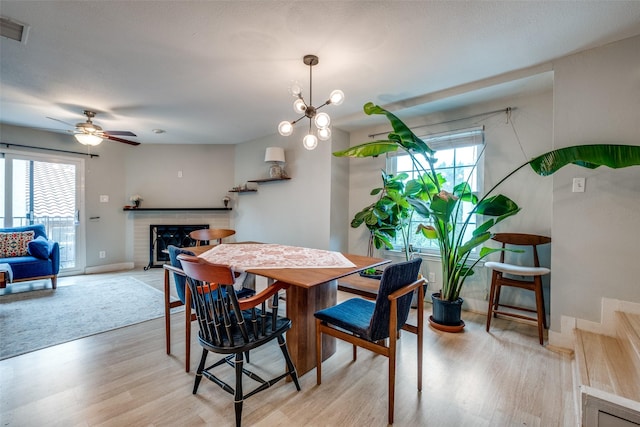 4777 Cedar Springs Rd Unit 8Q, Dallas, TX 75219 - dining space featuring plenty of natural light, light wood-style flooring, a fireplace, and baseboards