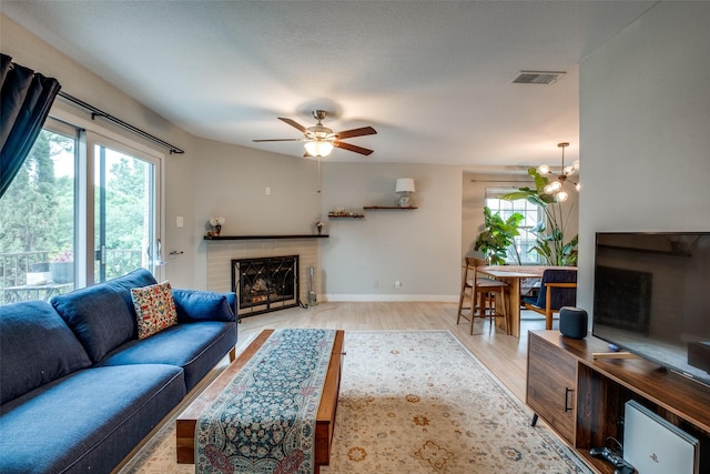 4777 Cedar Springs Rd Unit 8Q, Dallas, TX 75219 - living area featuring a fireplace, light wood finished floors, baseboards, and a ceiling fan