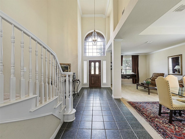 2937 Oakland Hills Dr, Plano, TX 75025 - foyer entrance with a chandelier, stairs, dark tile patterned flooring, crown molding, and a towering ceiling