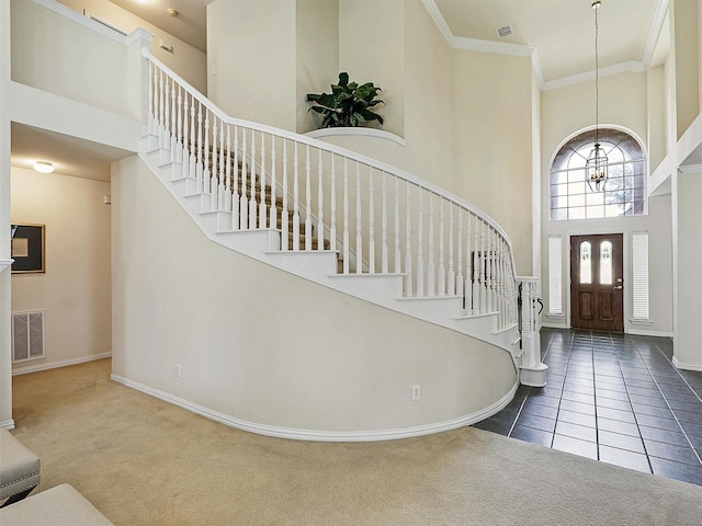 2937 Oakland Hills Dr, Plano, TX 75025 - carpeted foyer entrance with a towering ceiling, a chandelier, stairway, tile patterned floors, and crown molding