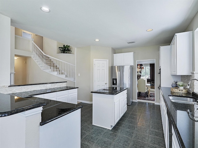 2937 Oakland Hills Dr, Plano, TX 75025 - kitchen with a center island, stainless steel refrigerator with ice dispenser, white cabinets, recessed lighting, and dark stone countertops