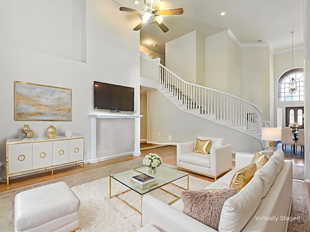 2937 Oakland Hills Dr, Plano, TX 75025 - living room with a towering ceiling, stairs, wood finished floors, ceiling fan, and ornamental molding