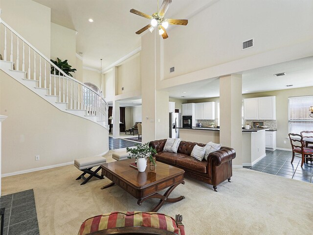 2937 Oakland Hills Dr, Plano, TX 75025 - living room with light colored carpet, stairway, a ceiling fan, and a towering ceiling