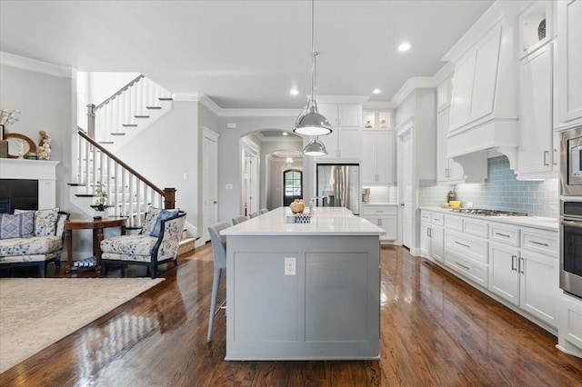 3770 W 5th St, Fort Worth, TX 76107 - kitchen featuring stainless steel appliances, arched walkways, white cabinetry, dark wood-type flooring, and crown molding