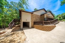 303 Llano Bnd, Holly Lake Ranch, TX 75765 - view of property exterior with stairs, a garage, and concrete driveway