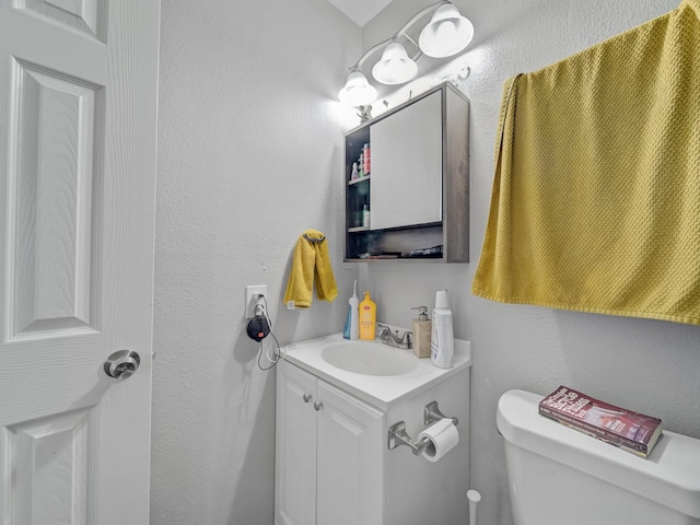 7831 San Jose Ave, Dallas, TX 75241 - bathroom featuring toilet, vanity, and a textured wall