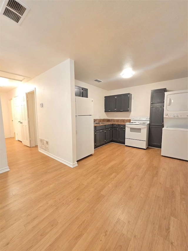201 Paschal, Troup, TX 75789 - kitchen with white appliances, estacked washer and dryer, light wood finished floors, baseboards, and light countertops