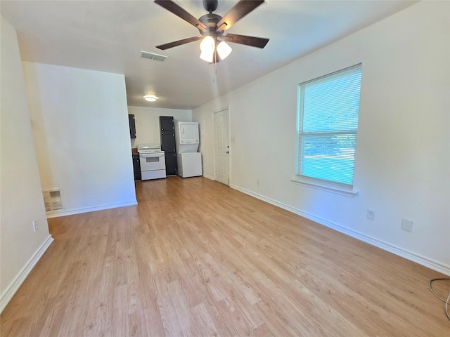 201 Paschal, Troup, TX 75789 - empty room featuring stacked washer / drying machine, light wood-style floors, ceiling fan, and baseboards