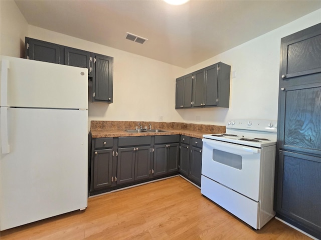 201 Paschal, Troup, TX 75789 - kitchen with white appliances, dark countertops, a sink, and light wood-style floors
