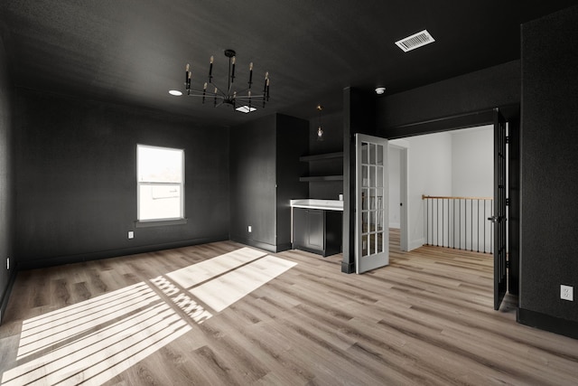 1228 Gould Ave, Fort Worth, TX 76164 - unfurnished living room with wood finished floors, baseboards, and a chandelier