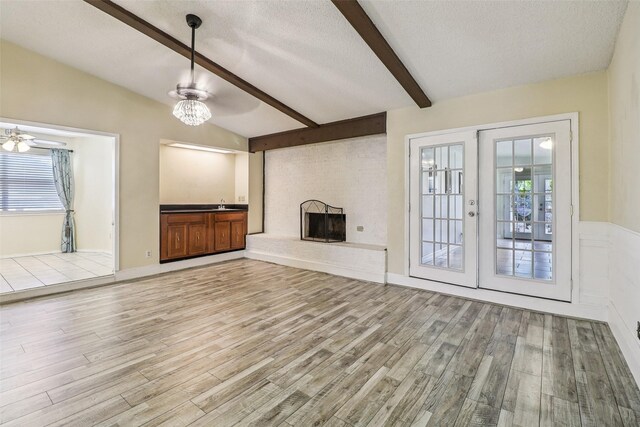 2622 Briar Hill Dr, Carrollton, TX 75007 - unfurnished living room with light wood-style floors, a large fireplace, plenty of natural light, and a textured ceiling