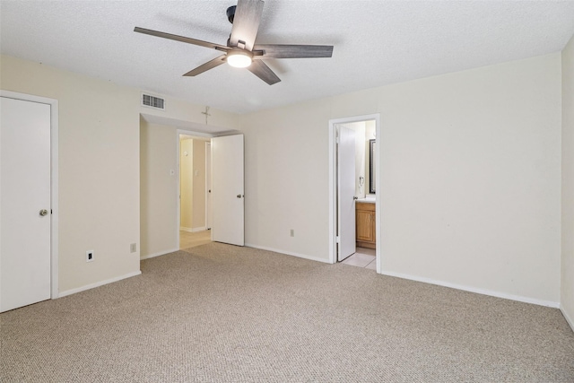 2622 Briar Hill Dr, Carrollton, TX 75007 - unfurnished bedroom featuring light carpet, baseboards, ensuite bathroom, and a textured ceiling