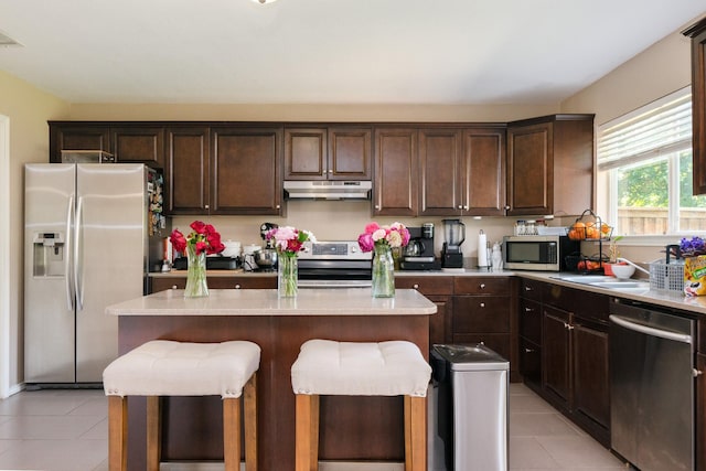 2300 Ash Grove Trl, Fort Worth, TX 76112 - kitchen with appliances with stainless steel finishes, under cabinet range hood, light tile patterned floors, and dark brown cabinetry