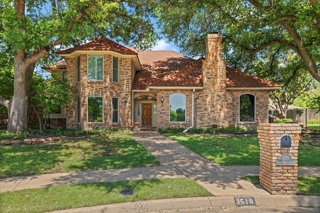 3519 Lake Powell Dr, Arlington, TX 76016 - view of front of home featuring a chimney, a front yard, and brick siding