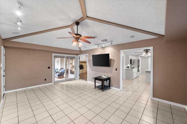240 Highland Knl, Highland Village, TX 75077 - unfurnished living room featuring a ceiling fan, track lighting, a textured ceiling, baseboards, and vaulted ceiling