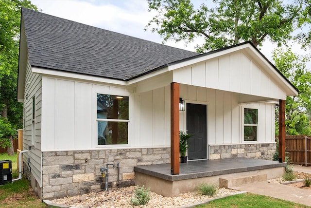 1111 N 11th St, Waco, TX 76707 - modern farmhouse style home featuring stone siding, a shingled roof, covered porch, central AC, and board and batten siding