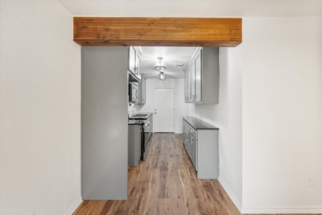 1111 N 11th St, Waco, TX 76707 - kitchen featuring appliances with stainless steel finishes, light wood finished floors, a sink, and baseboards