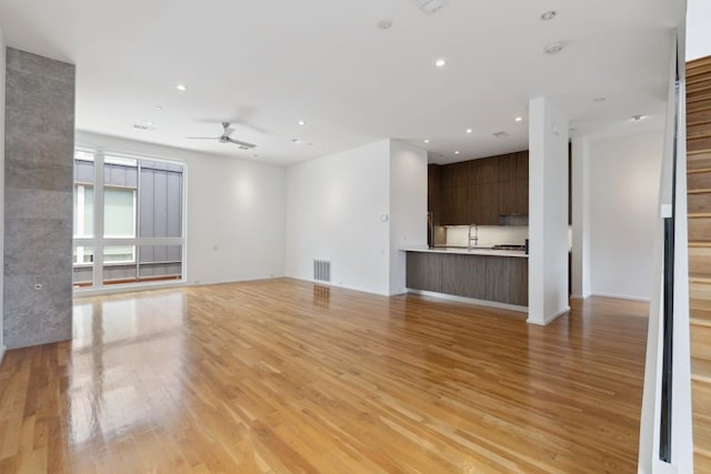 2706 Throckmorton St Unit C, Dallas, TX 75219 - unfurnished living room featuring a ceiling fan, light wood-style floors, recessed lighting, and a sink