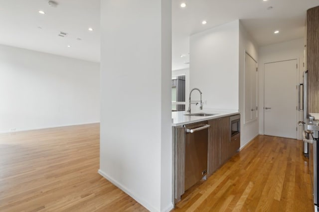2706 Throckmorton St Unit C, Dallas, TX 75219 - kitchen featuring stainless steel appliances, a sink, light wood-type flooring, modern cabinets, and recessed lighting