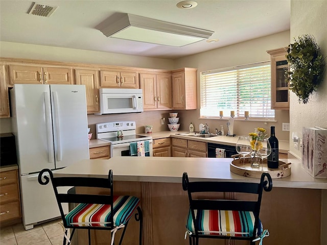 201 Park Rd, Nocona, TX 76255 - kitchen with white appliances, a sink, a breakfast bar area, and light brown cabinetry