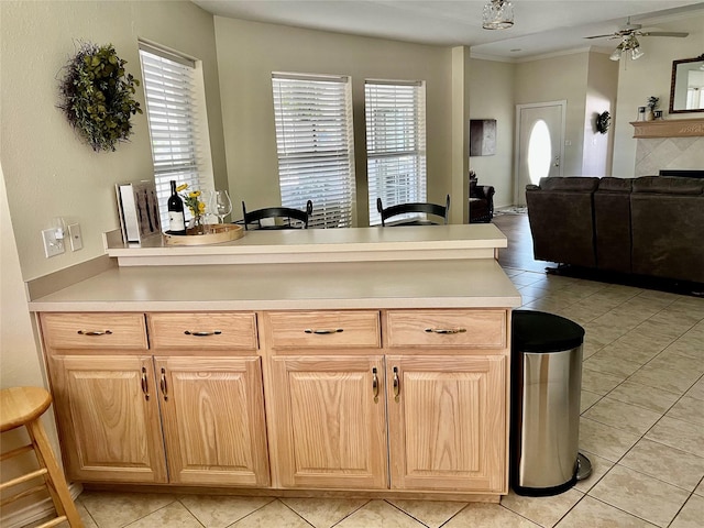 201 Park Rd, Nocona, TX 76255 - kitchen with a peninsula, ceiling fan, light countertops, light tile patterned flooring, and ornamental molding