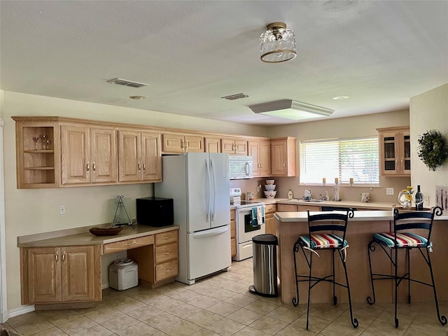 201 Park Rd, Nocona, TX 76255 - kitchen featuring white appliances, a breakfast bar, a peninsula, open shelves, and light brown cabinetry