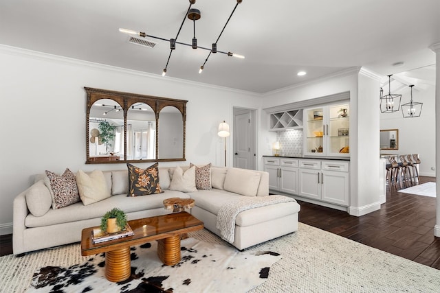 610 Sunset Ct, Argyle, TX 76226 - living room featuring ornamental molding, dark wood-type flooring, a chandelier, baseboards, and a bar