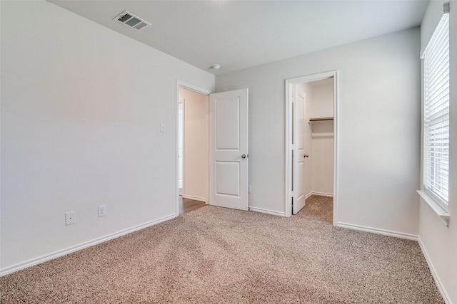 1302 Lowhill Dr, Royse City, TX 75189 - unfurnished bedroom featuring carpet, multiple windows, baseboards, and a walk in closet