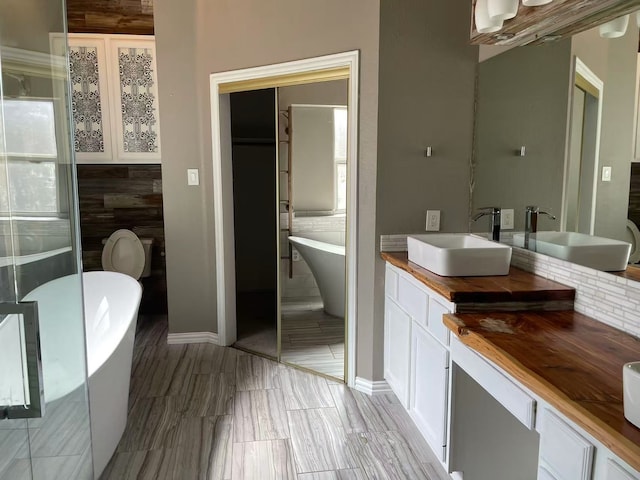 11008 Hermitage Ln, Frisco, TX 75035 - bathroom with a freestanding bath, double vanity, and baseboards