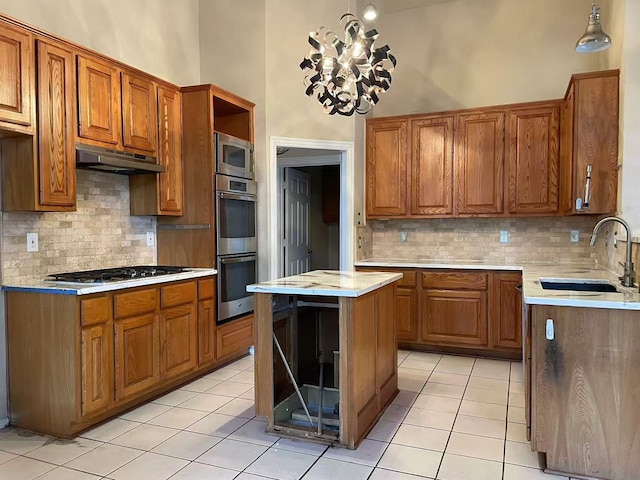 11008 Hermitage Ln, Frisco, TX 75035 - kitchen featuring a sink, under cabinet range hood, stainless steel appliances, brown cabinetry, and a high ceiling