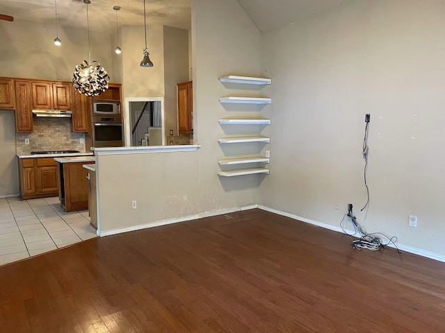 11008 Hermitage Ln, Frisco, TX 75035 - kitchen featuring brown cabinets, open shelves, appliances with stainless steel finishes, light wood finished floors, and high vaulted ceiling