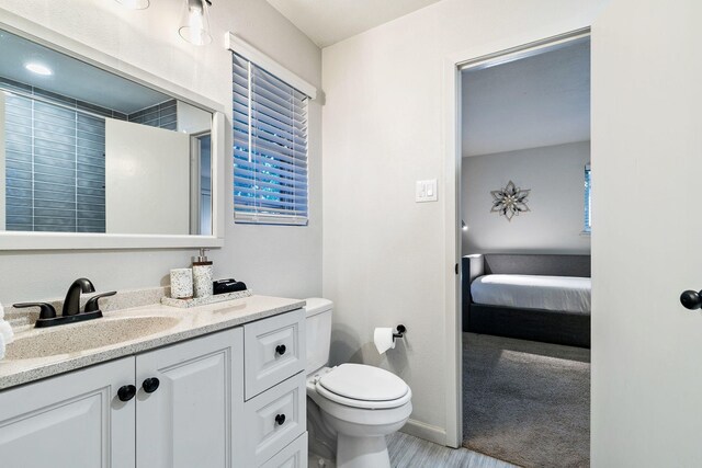 5308 Blaney Way, Dallas, TX 75227 - bathroom featuring toilet, vanity, ensuite bath, baseboards, and wood finished floors