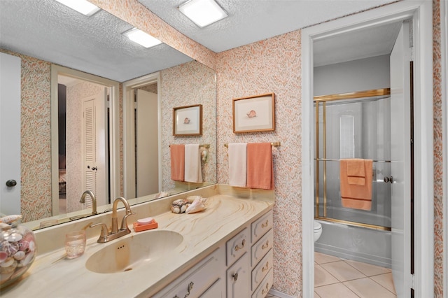 408 Hollyhill Ln, Denton, TX 76205 - bathroom with vanity, toilet, a textured ceiling, bath / shower combo with glass door, and tile patterned flooring