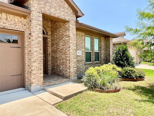 2518 Lavender Ln, Glenn Heights, TX 75154 - entrance to property with an attached garage, brick siding, and a lawn
