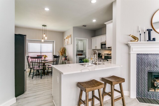 4124 Creekhollow, Carrollton, TX 75010 - kitchen with appliances with stainless steel finishes, a peninsula, white cabinetry, light wood finished floors, and recessed lighting
