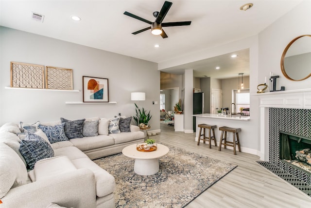 4124 Creekhollow, Carrollton, TX 75010 - living room featuring light wood-style floors, a ceiling fan, baseboards, recessed lighting, and a fireplace