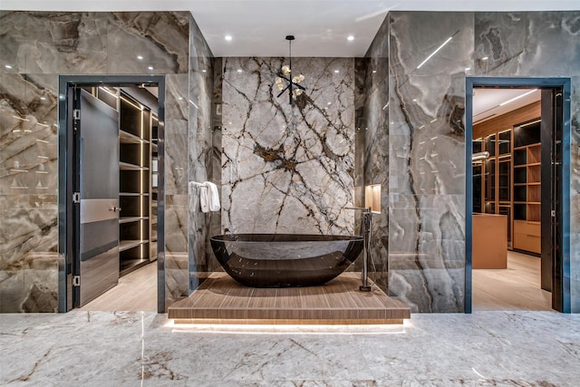 10846 Crooked Creek Ct, Dallas, TX 75229 - full bath with tile walls, stone wall, a soaking tub, and marble tiled floors