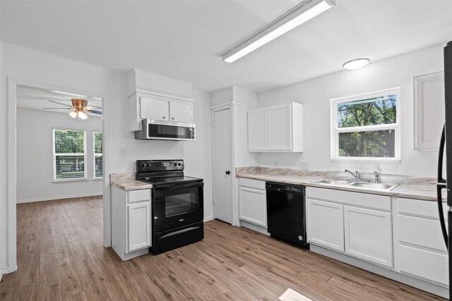 307 Soward Ave, Weatherford, TX 76086 - kitchen with black appliances, a sink, light wood-type flooring, white cabinetry, and light countertops