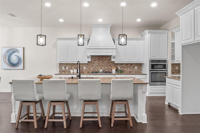 2820 Annandale Dr, Trophy Club, TX 76262 - kitchen with stainless steel double oven, tasteful backsplash, gas cooktop, custom range hood, and white cabinets