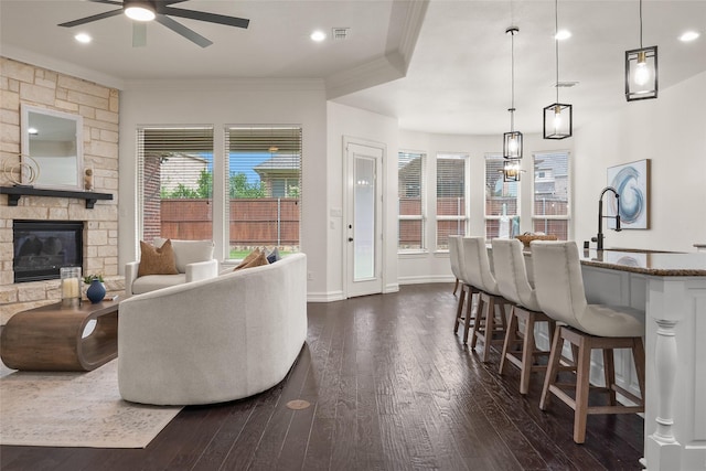 2820 Annandale Dr, Trophy Club, TX 76262 - living room featuring ornamental molding, a ceiling fan, dark wood-style floors, a stone fireplace, and baseboards