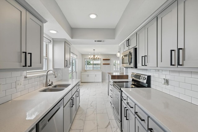 4448 Atlanta Dr, Plano, TX 75093 - kitchen with appliances with stainless steel finishes, a sink, gray cabinetry, light marble finish floors, and recessed lighting