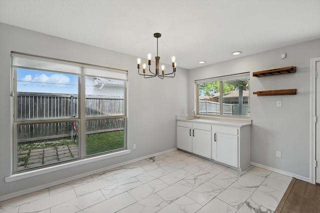 4448 Atlanta Dr, Plano, TX 75093 - unfurnished dining area with a chandelier, baseboards, a sink, light marble finish floors, and recessed lighting