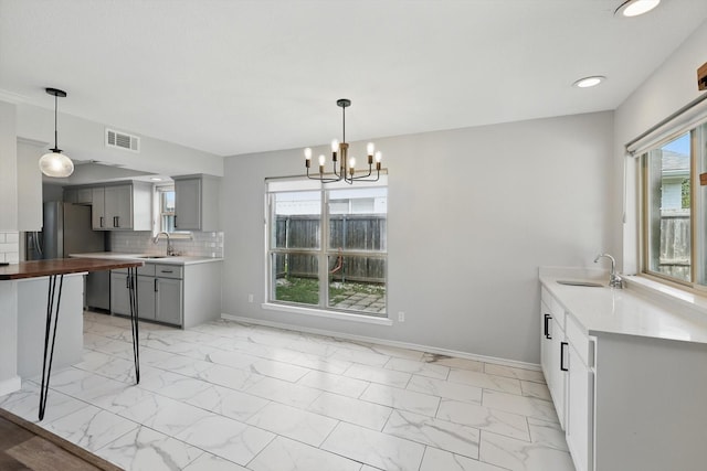 4448 Atlanta Dr, Plano, TX 75093 - kitchen with gray cabinetry, a sink, light marble finish floors, a chandelier, and recessed lighting