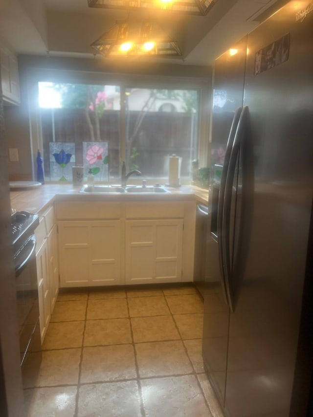 2665 Via, Los Altos, Carrollton, TX 75006 - kitchen featuring freestanding refrigerator, a sink, range, white cabinetry, and light countertops
