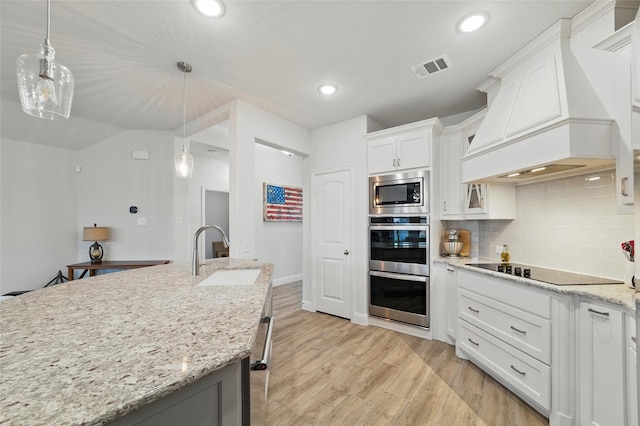 2109 Liriope Ln, Waxahachie, TX 75165 - kitchen with a sink, premium range hood, stainless steel appliances, backsplash, and white cabinetry