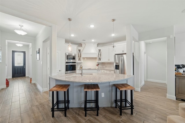 2109 Liriope Ln, Waxahachie, TX 75165 - kitchen with stainless steel appliances, custom exhaust hood, wood finish floors, a kitchen breakfast bar, and recessed lighting