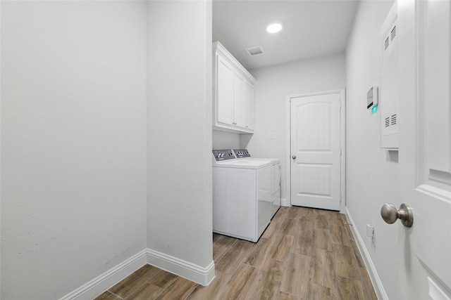 2109 Liriope Ln, Waxahachie, TX 75165 - laundry area featuring washer and clothes dryer, light wood-type flooring, baseboards, and cabinet space